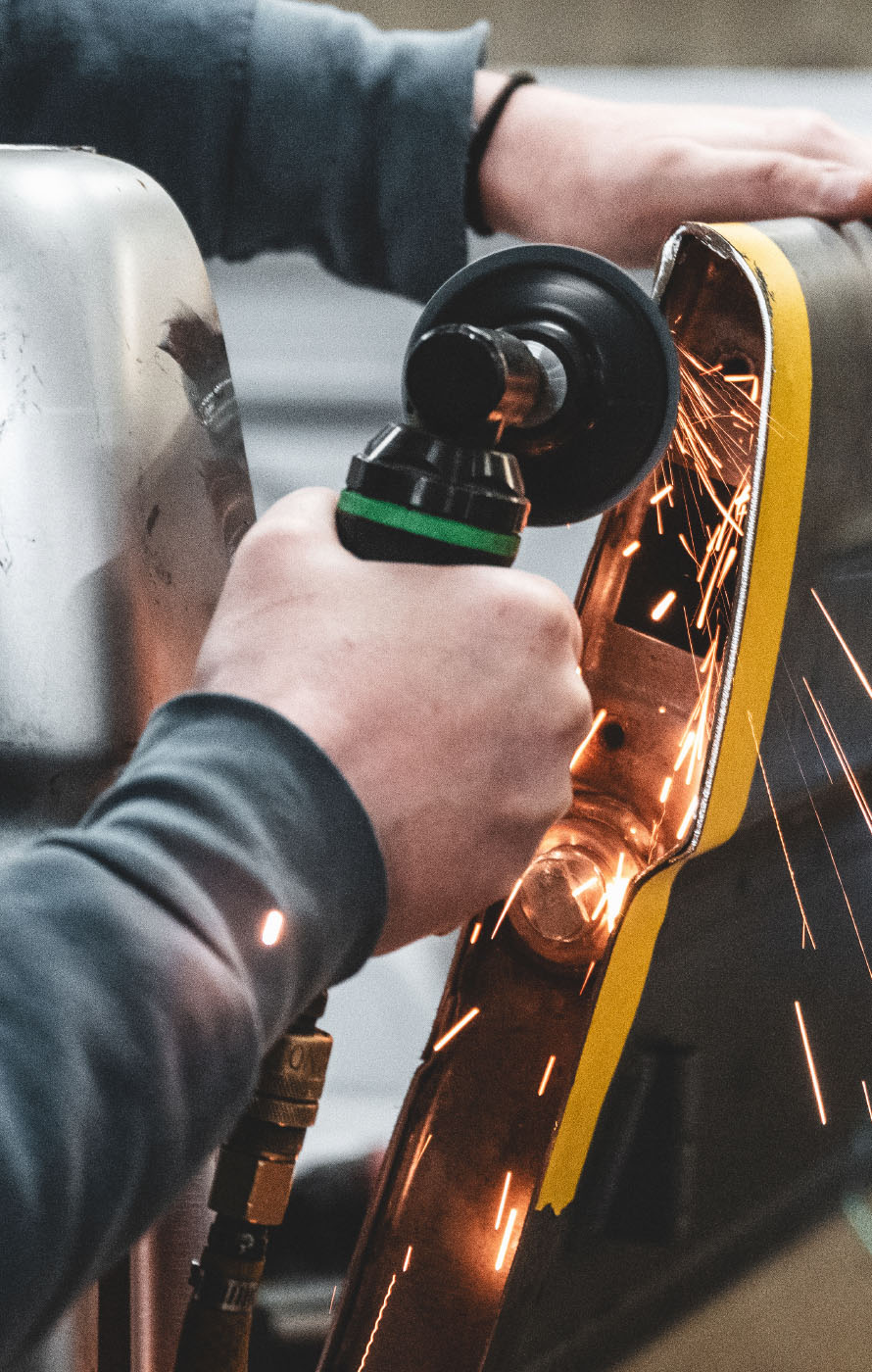 Man grinding metal with sparks flying on Rustbelt Offroad Website