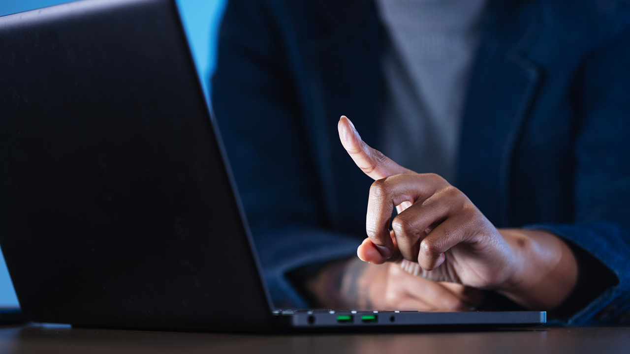 Person on laptop ready to press a key