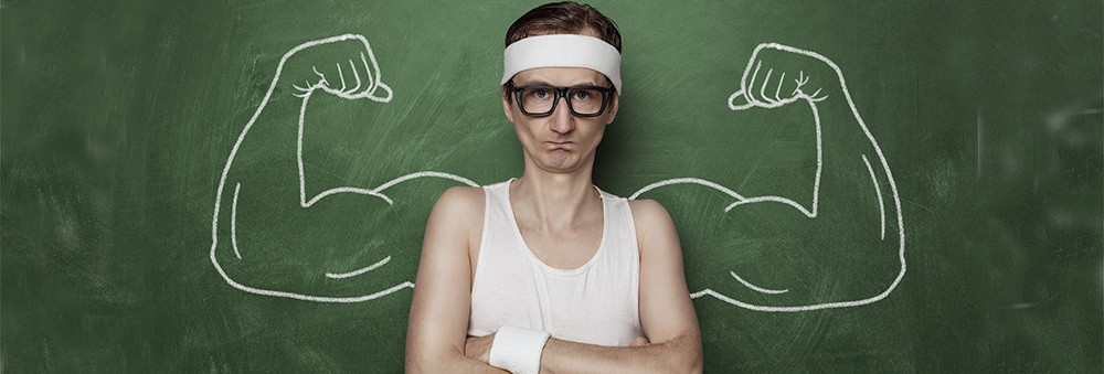 Skinny weak man in front of muscles drawn on blackboard