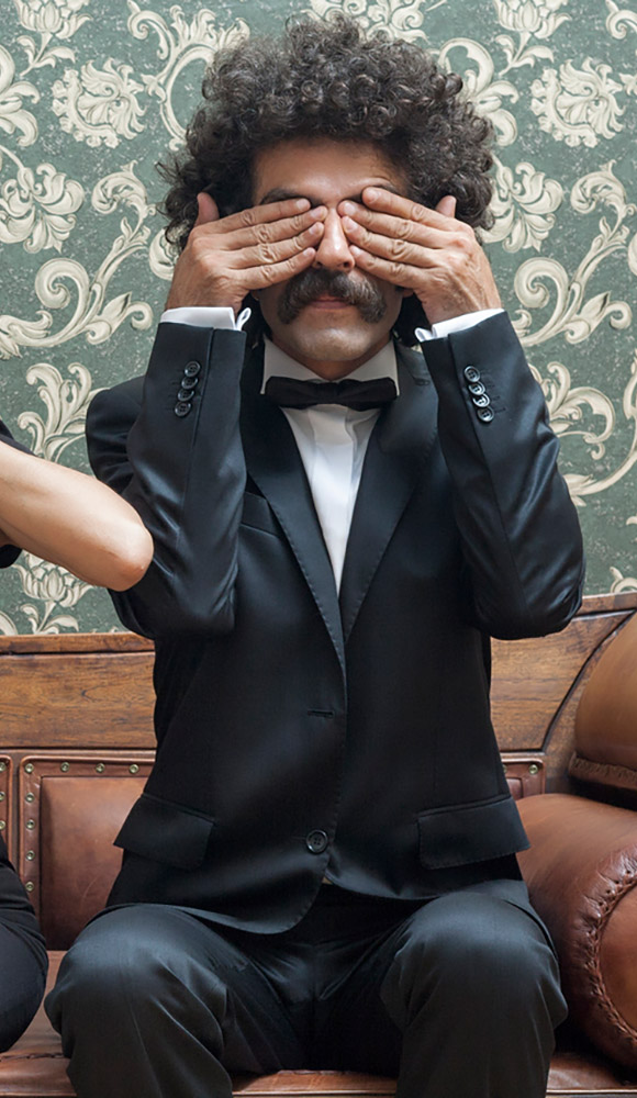 Man in suit with his hands over his eyes