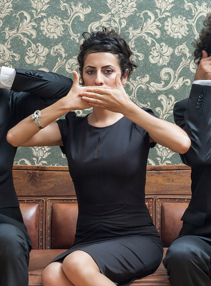 Woman in black holding her hands over her mouth